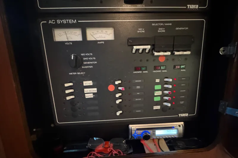 Slide: The Image of Electrical control panel of a 2000 Tiara 37 Open boat, featuring AC system meters and switches. - 104