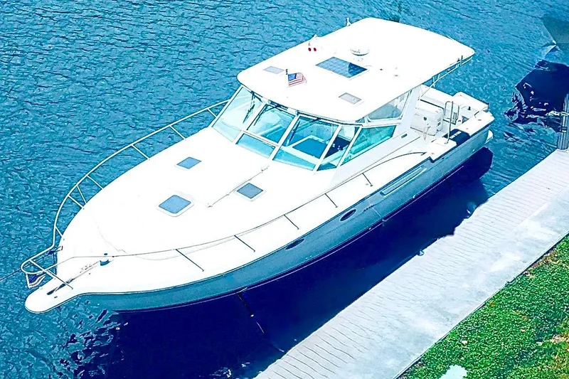Slide: The Image of 2000 Tiara 37 Open yacht docked on calm water, aerial view. - 60