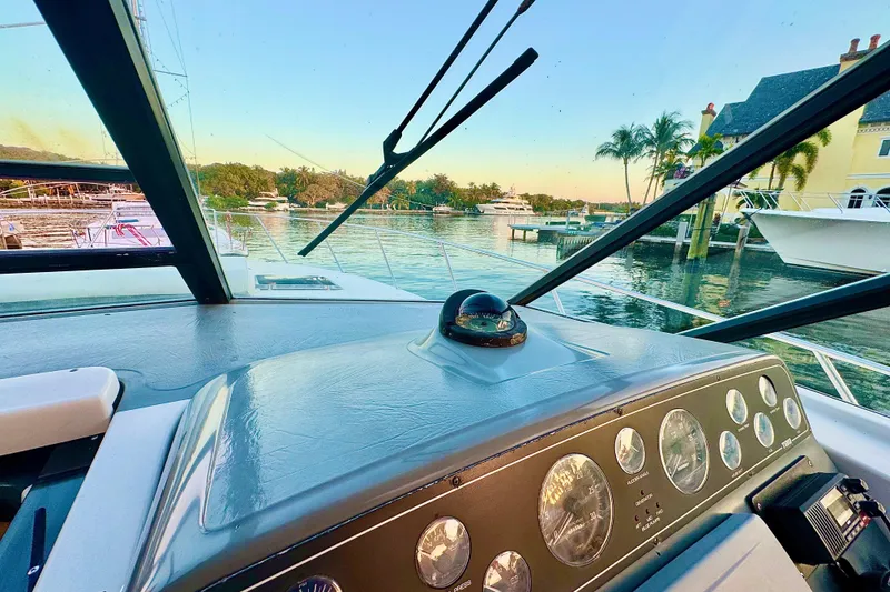 Slide: The Image of Cockpit view of 2000 Tiara 37 Open yacht, overlooking serene marina with palm trees. - 62