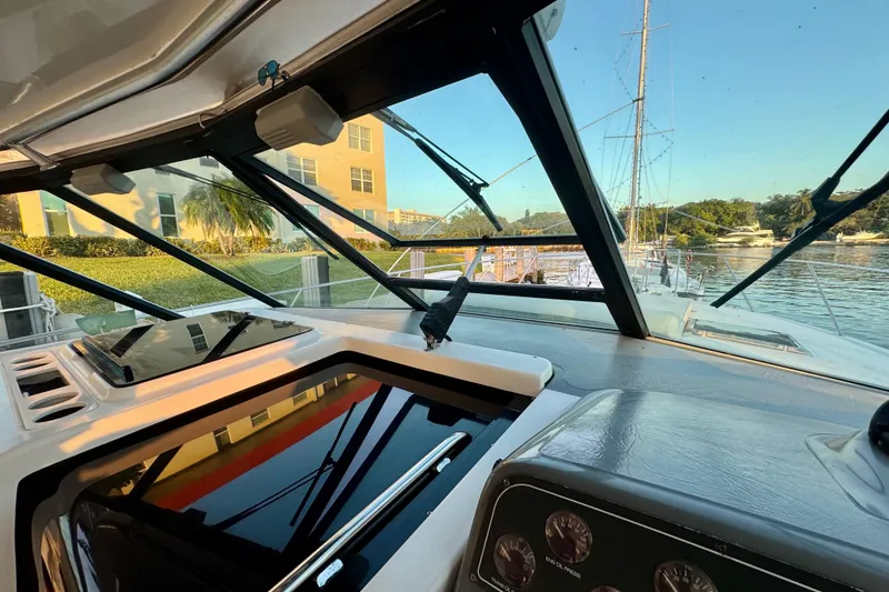 Slide: The Image of Interior view of 2000 Tiara 37 Open yacht cockpit with marina backdrop. - 76