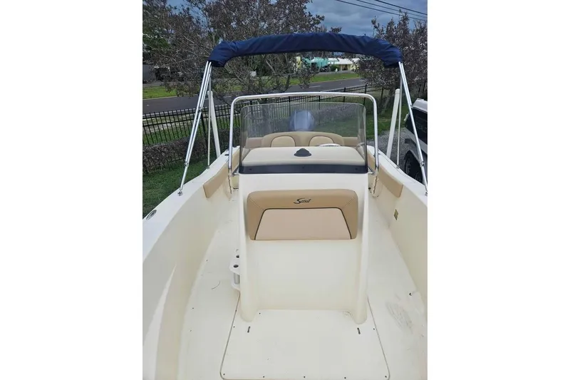 Slide: The Image of 2017 Scout 195 Sportfish boat with beige seating and blue canopy. - 12