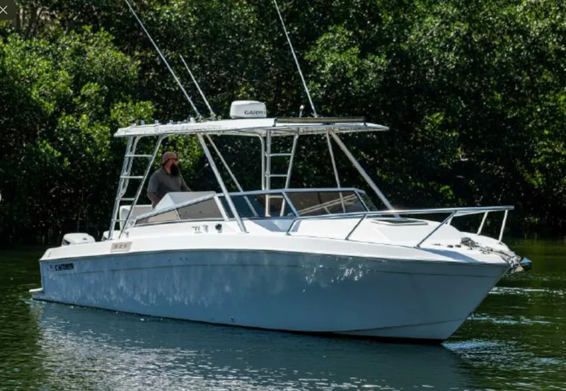 Slide: The Image of 2001 Contender 35 Side Console boat cruising on a calm waterway. - 2