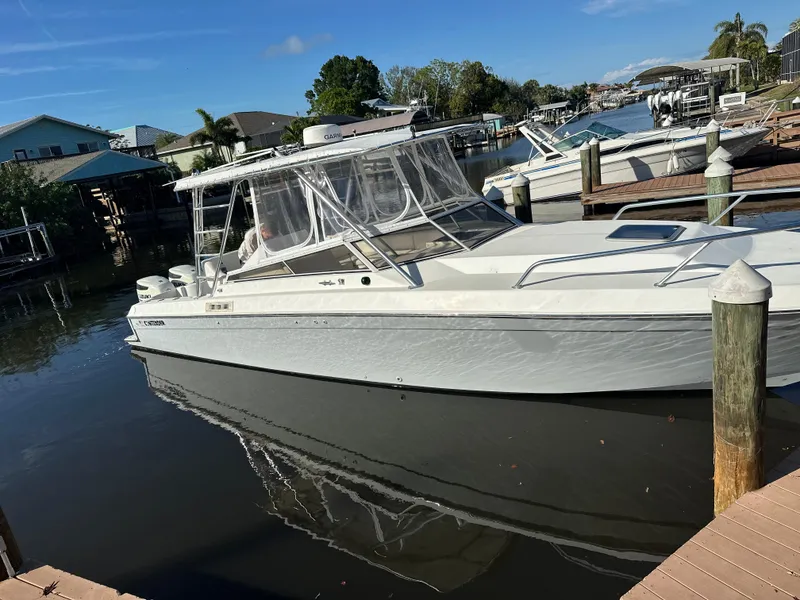Slide: The Image of 2001 Contender 35 Side Console boat docked in a marina under clear skies. - 4