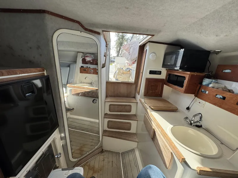 Slide: The Image of 2001 Contender 35 Side Console interior with kitchenette, sink, and wooden cabinetry. - 8