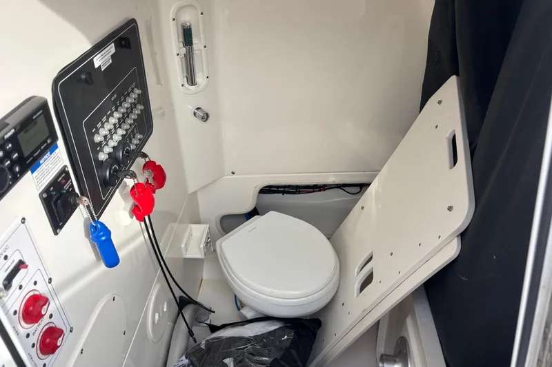 Slide: The Image of 2018 Boston Whaler 250 Outrage interior with control panel and marine toilet. - 18