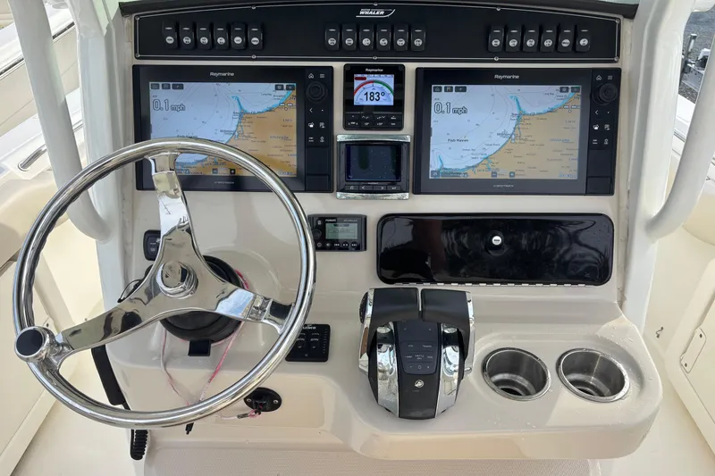 Slide: The Image of Boston Whaler 250 Outrage 2018 dashboard with navigation screens and steering wheel. - 4