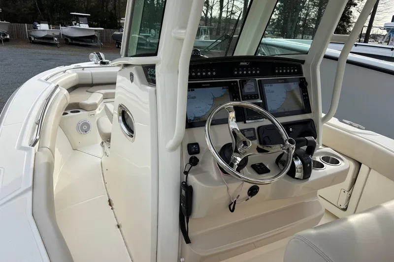 Slide: The Image of 2018 Boston Whaler 250 Outrage boat cockpit with steering wheel and navigation screens. - 5