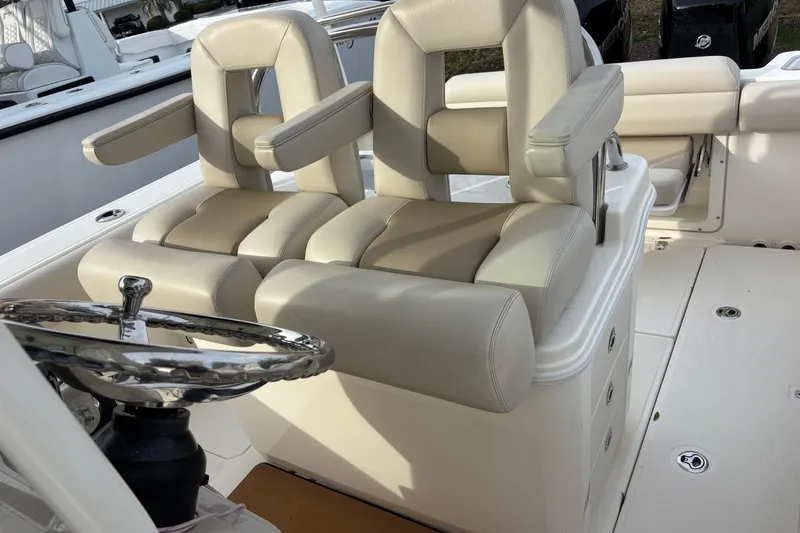 Slide: The Image of 2018 Boston Whaler 250 Outrage boat interior with dual helm seats and steering wheel. - 8