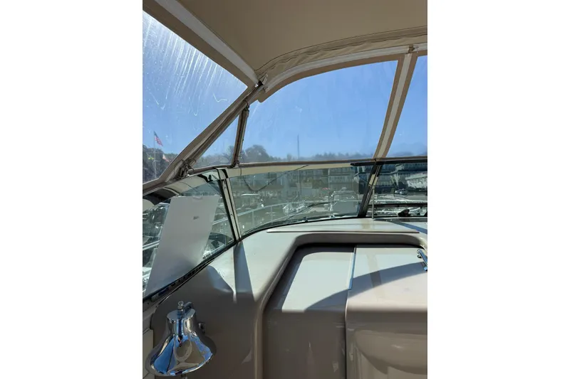 Slide: The Image of 2000 Sea Ray 410 Express Cruiser helm with clear canopy and marina view. - 17