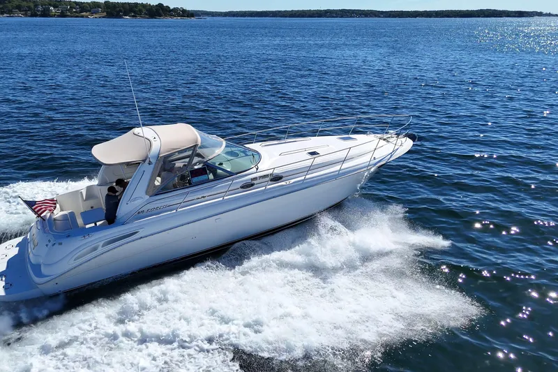 Slide: The Image of 2000 Sea Ray 410 Express Cruiser navigating on open water, showcasing sleek design and performance. - 2