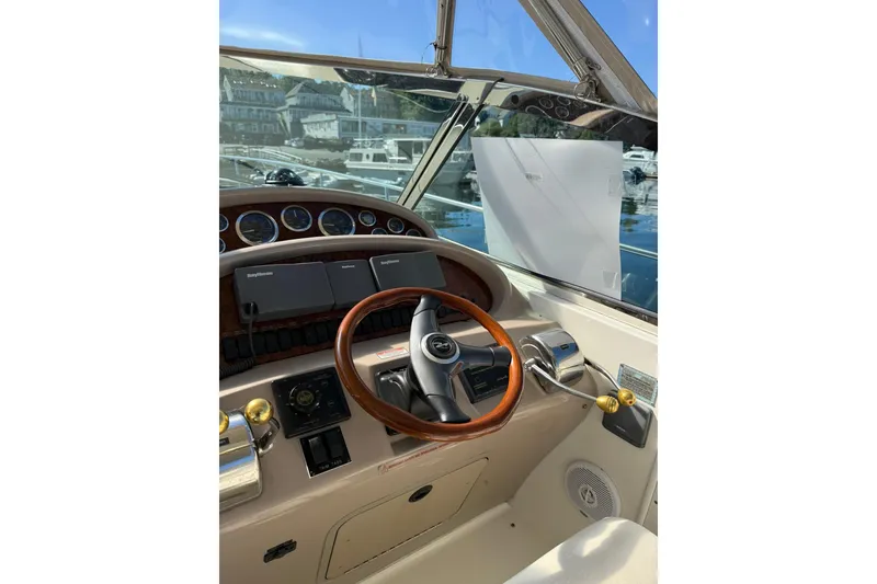 Slide: The Image of Helm of 2000 Sea Ray 410 Express Cruiser with wooden steering wheel and navigation instruments. - 25