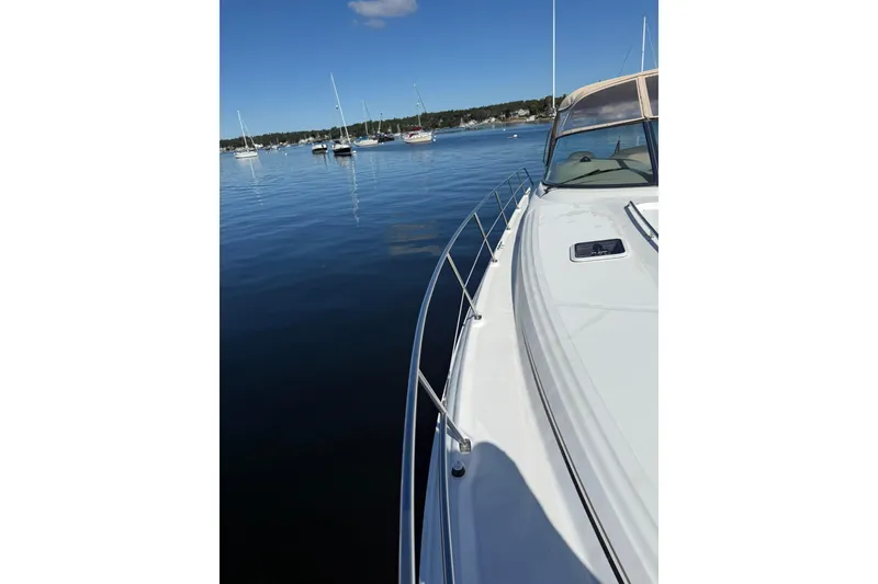 Slide: The Image of 2000 Sea Ray 410 Express Cruiser on calm water with sailboats in the background. - 35
