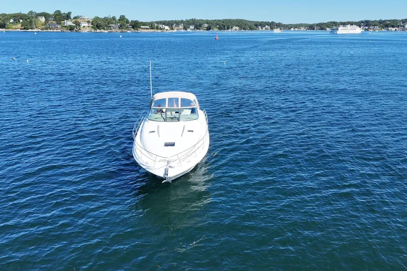 Slide: The Image of 2000 Sea Ray 410 Express Cruiser on calm blue water, distant shoreline visible. - 4