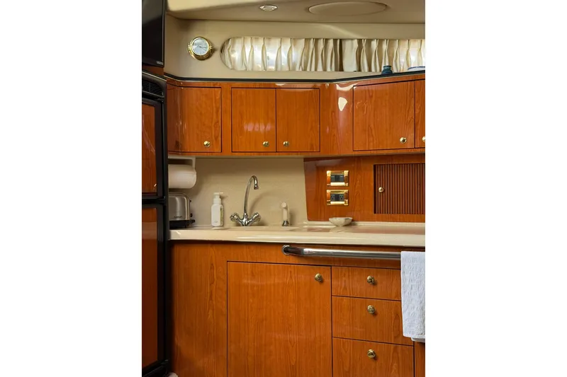 Slide: The Image of Luxurious kitchen interior of 2000 Sea Ray 410 Express Cruiser with wooden cabinets. - 45