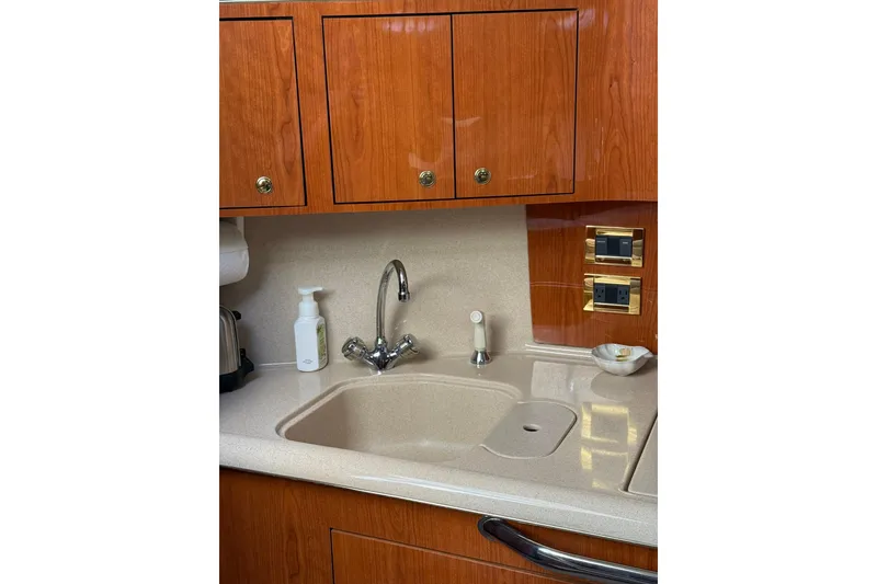Slide: The Image of Kitchen area of 2000 Sea Ray 410 Express Cruiser with wooden cabinets and sink. - 47