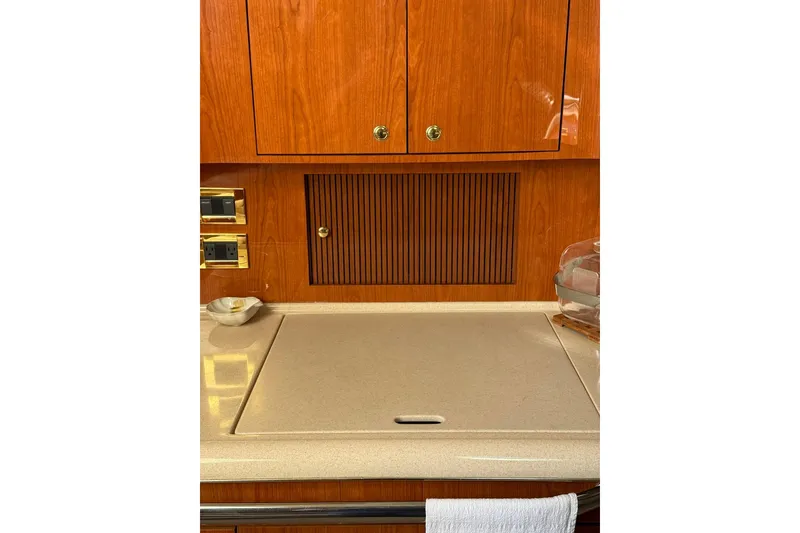 Slide: The Image of 2000 Sea Ray 410 Express Cruiser kitchen with wooden cabinets and countertop. - 48