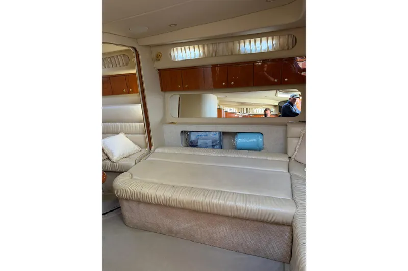 Slide: The Image of Interior of 2000 Sea Ray 410 Express Cruiser with beige seating and wooden cabinets. - 58