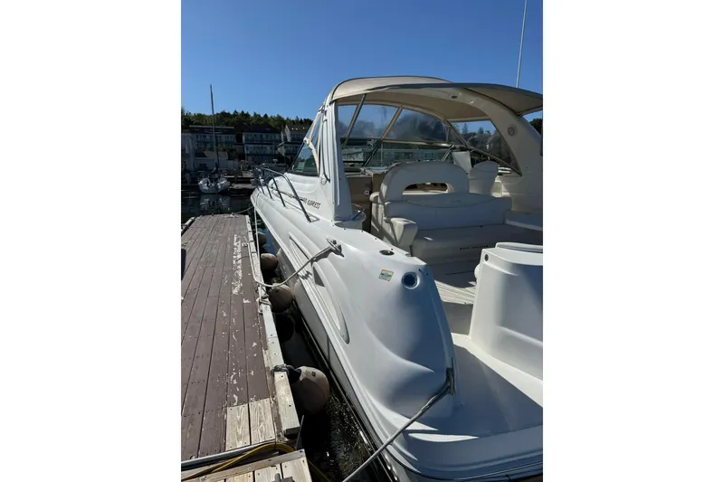 Slide: The Image of 2000 Sea Ray 410 Express Cruiser docked at marina under clear blue sky. - 6