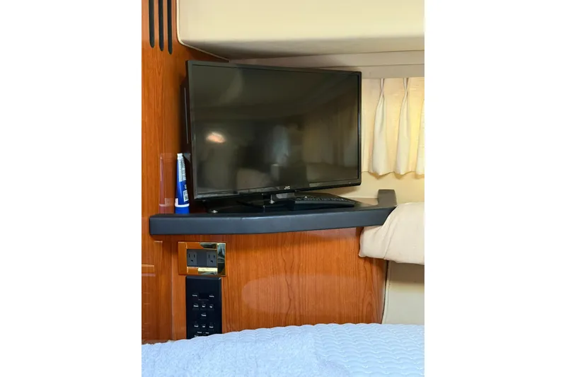 Slide: The Image of 2000 Sea Ray 410 Express Cruiser interior with TV and wooden cabinetry. - 69