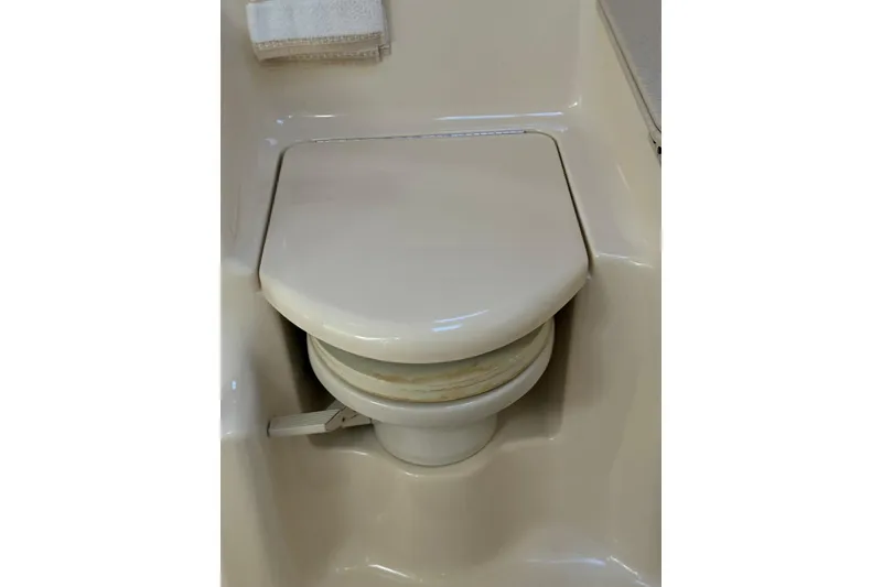 Slide: The Image of Marine toilet in 2000 Sea Ray 410 Express Cruiser, featuring compact design and beige color. - 76