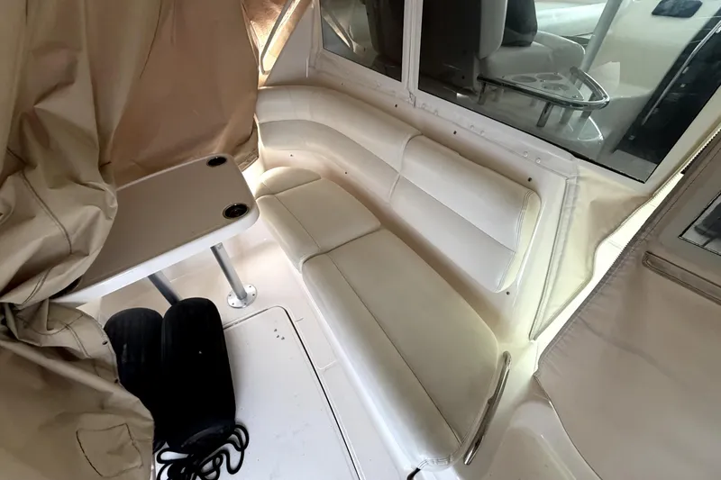Slide: The Image of Interior seating area of 2006 Tiara Yachts 4300 Sovran, featuring white upholstery and table. - 2