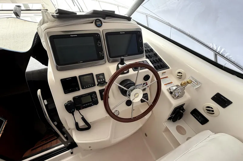 Slide: The Image of Helm of 2006 Tiara Yachts 4300 Sovran with dual Raymarine displays and wooden steering wheel. - 4