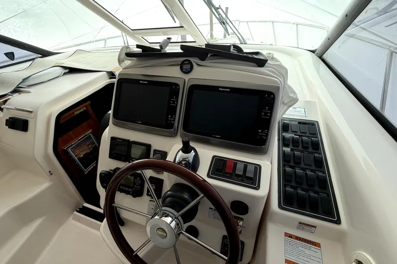 Slide: The Image of 2006 Tiara Yachts 4300 Sovran helm with dual Raymarine displays and wooden steering wheel. - 5