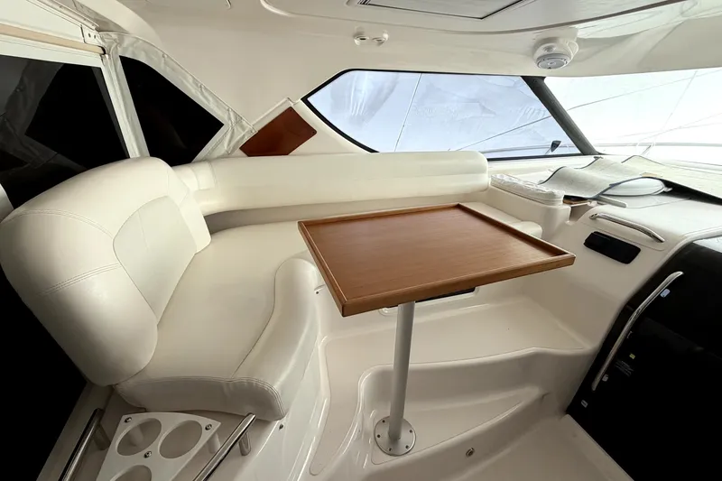 Slide: The Image of Luxurious interior of 2006 Tiara Yachts 4300 Sovran with white seating and wooden table. - 6