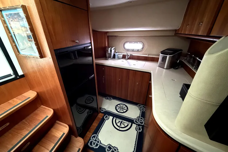Slide: The Image of 2006 Tiara Yachts 4300 Sovran galley with wood cabinetry and modern appliances. - 8