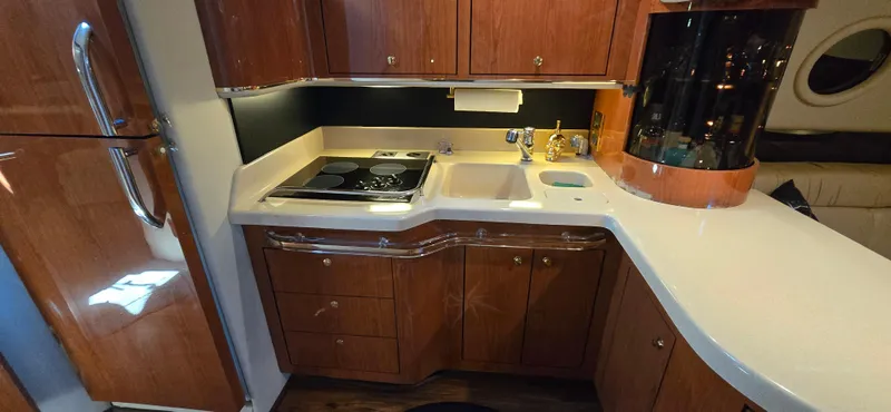 Slide: The Image of Luxurious kitchen area in 1999 Sea Ray 50 Sundancer yacht with wood cabinetry and modern appliances. - 15