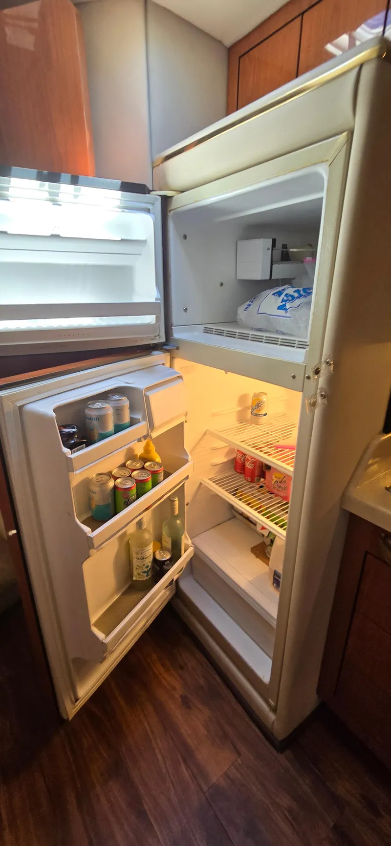 Slide: The Image of Open refrigerator inside 1999 Sea Ray 50 Sundancer yacht, stocked with beverages. - 16