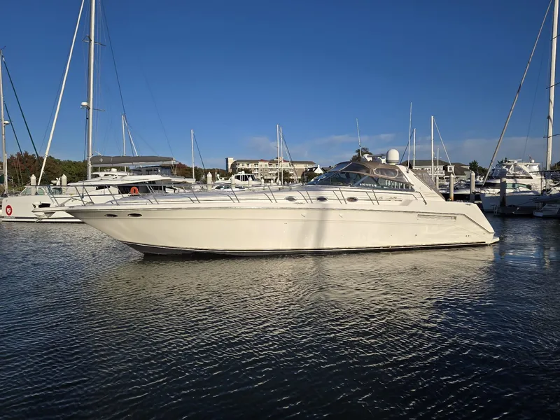 Slide: The Image of 1999 Sea Ray 50 Sundancer yacht docked in a marina under clear blue skies. - 2