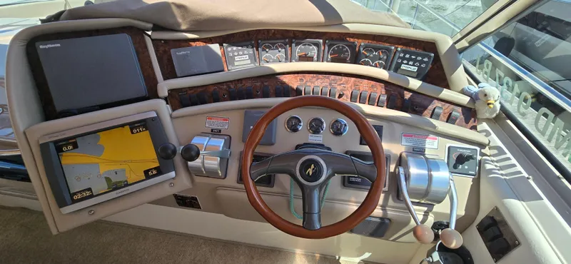 Slide: The Image of 1999 Sea Ray 50 Sundancer helm with navigation screens and controls. - 8