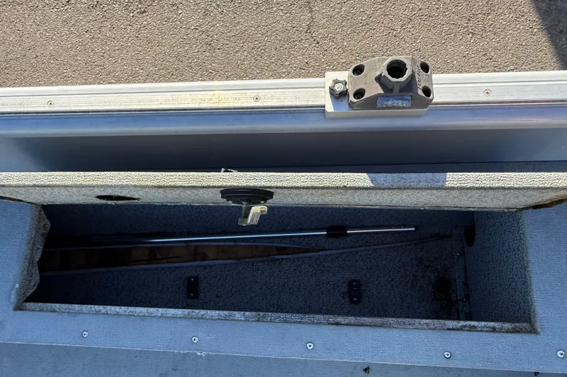 Slide: The Image of 2015 Smoker Craft Freedom 160 TL boat storage compartment with open lid and visible rod holder. - 17