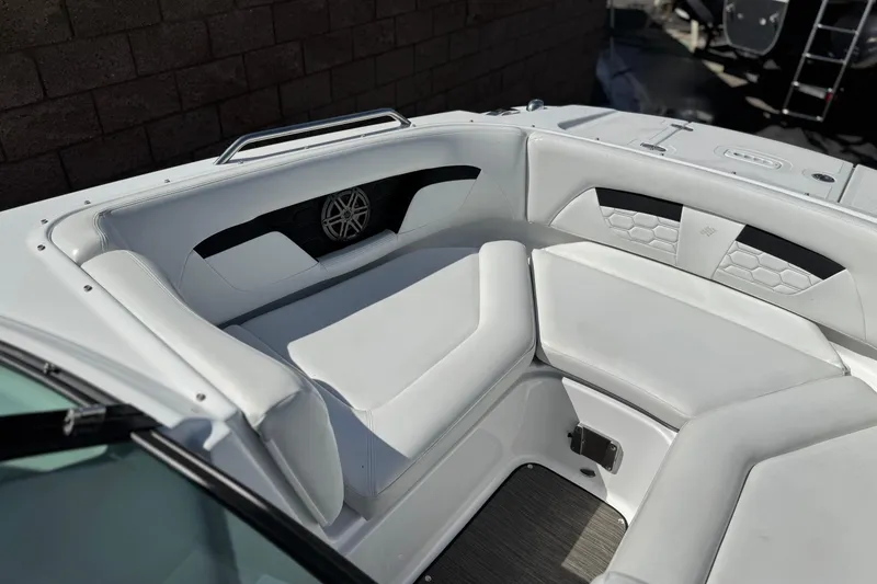 Slide: The Image of 2023 Four Winns HD3 boat interior with white cushioned seating and speaker detail. - 16