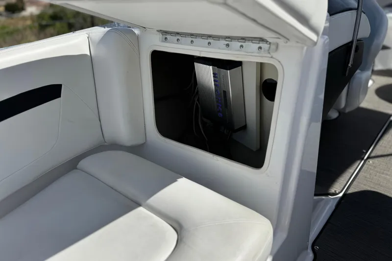 Slide: The Image of 2023 Four Winns HD3 boat storage compartment with electronic equipment inside. - 18