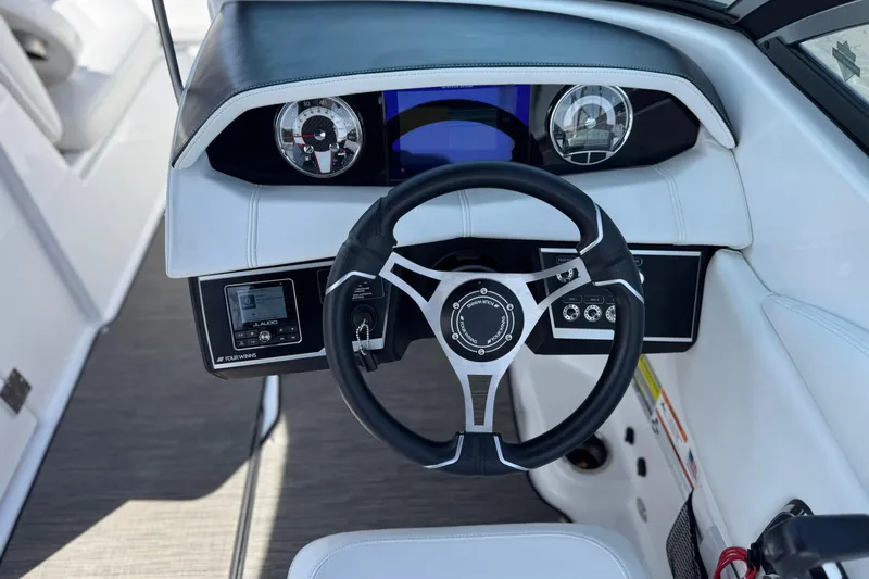 Slide: The Image of 2023 Four Winns HD3 boat dashboard with steering wheel and gauges. - 34
