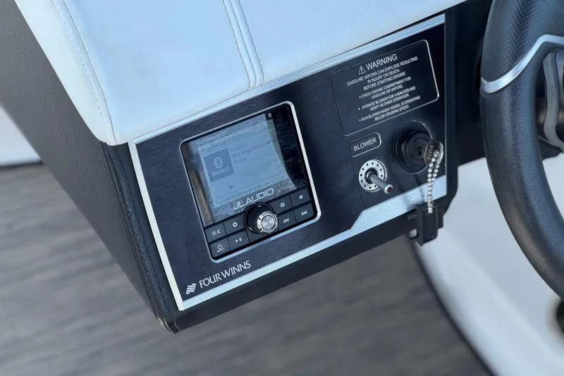 Slide: The Image of 2023 Four Winns HD3 boat dashboard with JL Audio system and ignition key. - 35