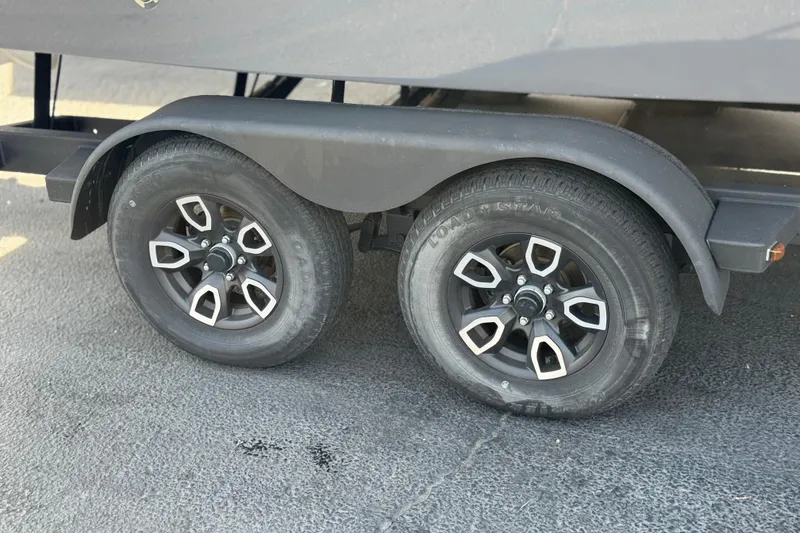 Slide: The Image of Trailer wheels of a 2023 Four Winns HD3 boat on pavement. - 38