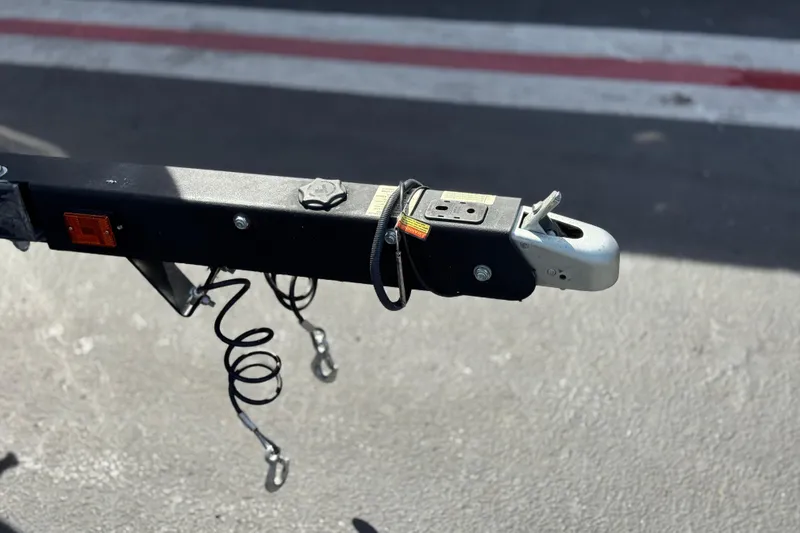 Slide: The Image of Trailer hitch of a 2023 Four Winns HD3 boat on pavement. - 39