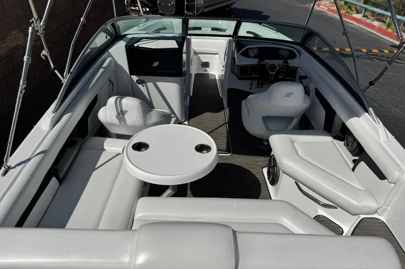 Slide: The Image of Interior of 2023 Four Winns HD3 boat with white seating and round table. - 9