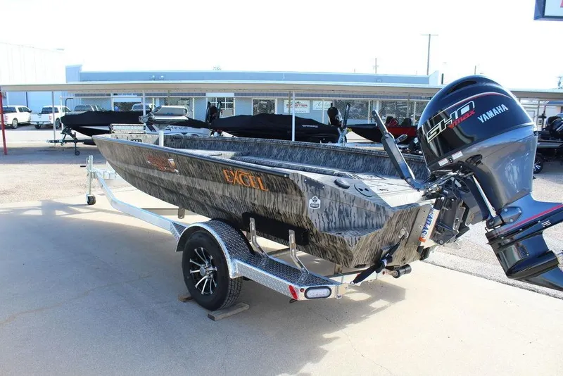 Slide: The Image of 2026 Excel 183 Tomahawk boat with Yamaha engine on trailer, parked outdoors. - 8