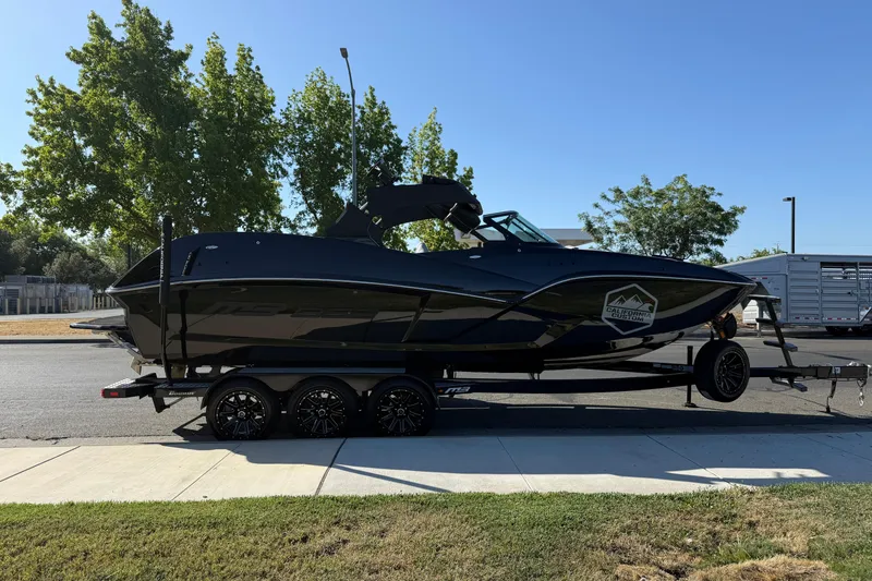 The Image of 2025 MB B52 25 Alpha boat on trailer, parked on street, sunny day. - 1