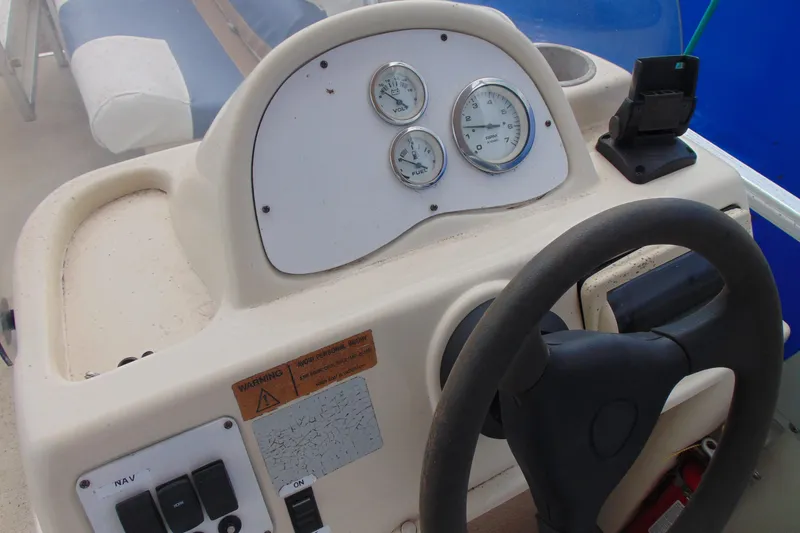 Slide: The Image of Steering console of a 2004 Forrest River 1903 boat with gauges and controls. - 12