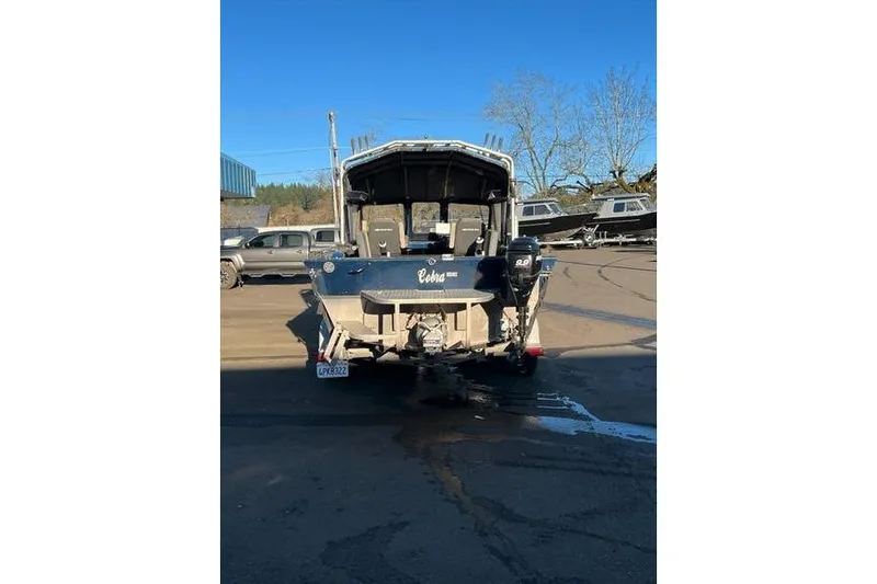 Slide: The Image of 2023 Custom Weld Cobra boat parked outdoors, rear view with clear blue sky. - 4
