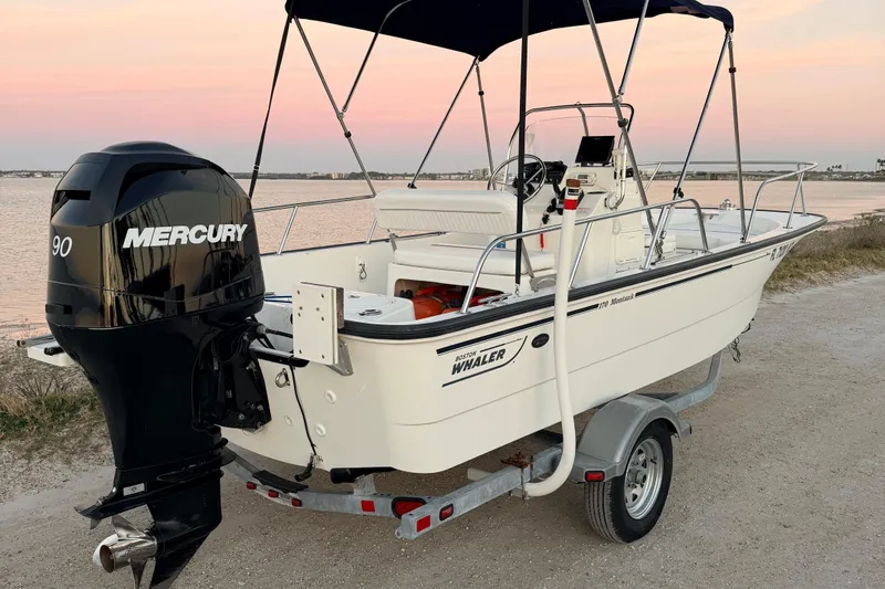 The Image of 2010 Boston Whaler 170 Montauk boat with Mercury 90 engine on trailer at sunset. - 0
