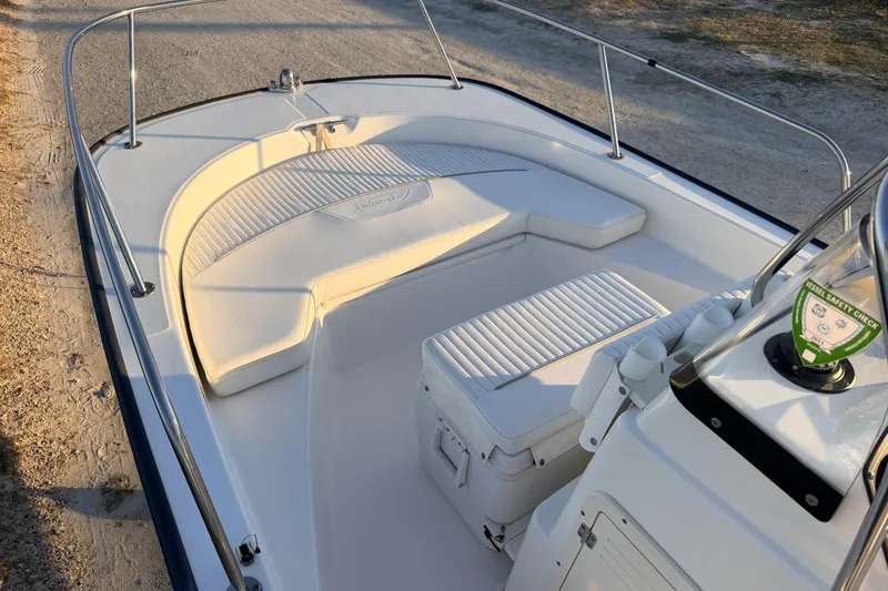 Slide: The Image of 2010 Boston Whaler 170 Montauk boat interior with cushioned seating and safety check sticker. - 18