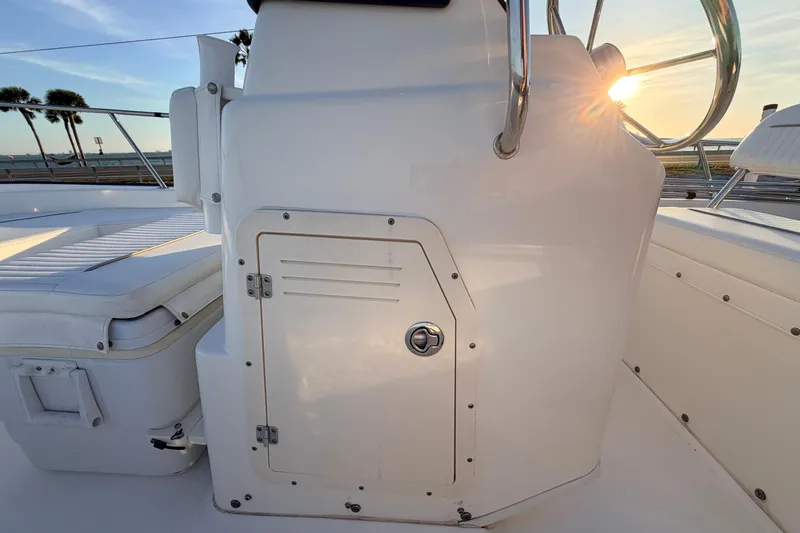 Slide: The Image of 2010 Boston Whaler 170 Montauk boat interior with storage compartment and seating, sunset view. - 29