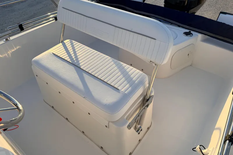 Slide: The Image of 2010 Boston Whaler 170 Montauk boat interior with white seating and steering wheel. - 39
