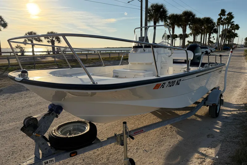 Slide: The Image of 2010 Boston Whaler 170 Montauk boat on trailer at sunset, near palm trees. - 4